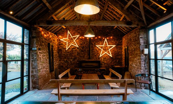 Interior of stone barn meeting space with star lights and low table with benches